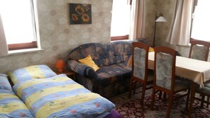 Une pièce comprenant un canapé, un fauteuil, une table et une lampe.