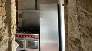 A kitchen with a stainless steel refrigerator, a gas stove, and an oven.