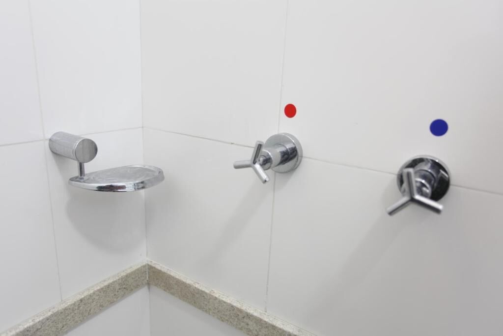 Een hoek van een badkamer met een toilet, een bidet en een wastafel.