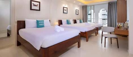 A hotel room with two beds, a desk, and a chair.