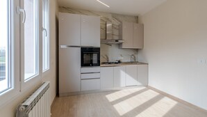 A modern kitchen with white cabinetry, a built-in oven, and a window providing natural light. - A bright and welcoming 90 square meters apartment, perfect for seven people, located on the first floor of a building without an elevator.The property is located in Tessera, a suburb close to Marco Polo Airport. The location is also ideal for reaching Ve (Venice)