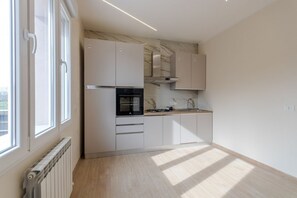 A modern kitchen with white cabinetry, a built-in oven, and a window providing natural light. - A bright and welcoming 90 square meters apartment, perfect for seven people, located on the first floor of a building without an elevator.The property is located in Tessera, a suburb close to Marco Polo Airport. The location is also ideal for reaching Ve (Venice)