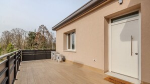 A modern building with a flat roof, a white door, and a welcome mat. - A bright and welcoming 90 square meters apartment, perfect for seven people, located on the first floor of a building without an elevator.The property is located in Tessera, a suburb close to Marco Polo Airport. The location is also ideal for reaching Ve (Venice)