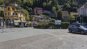 Una calle adoquinada con edificios, un coche estacionado y un cartel que dice 'San Giorgio'.