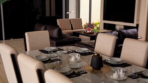 Een eetgedeelte met een tafel voor vier personen, omringd door leren banken en stoelen.