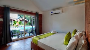 Una habitación de hotel con una cama, vista a una piscina y un equipo de aire acondicionado.