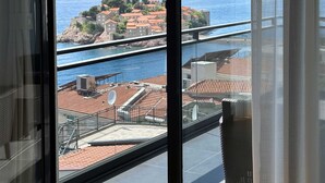 Un balcon donnant sur une ville côtière et la mer.