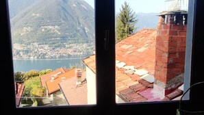 A window with a view of a mountainous landscape, a lake, and a village. - Little Gem Challet - Trekking House Como Lake (Torno)