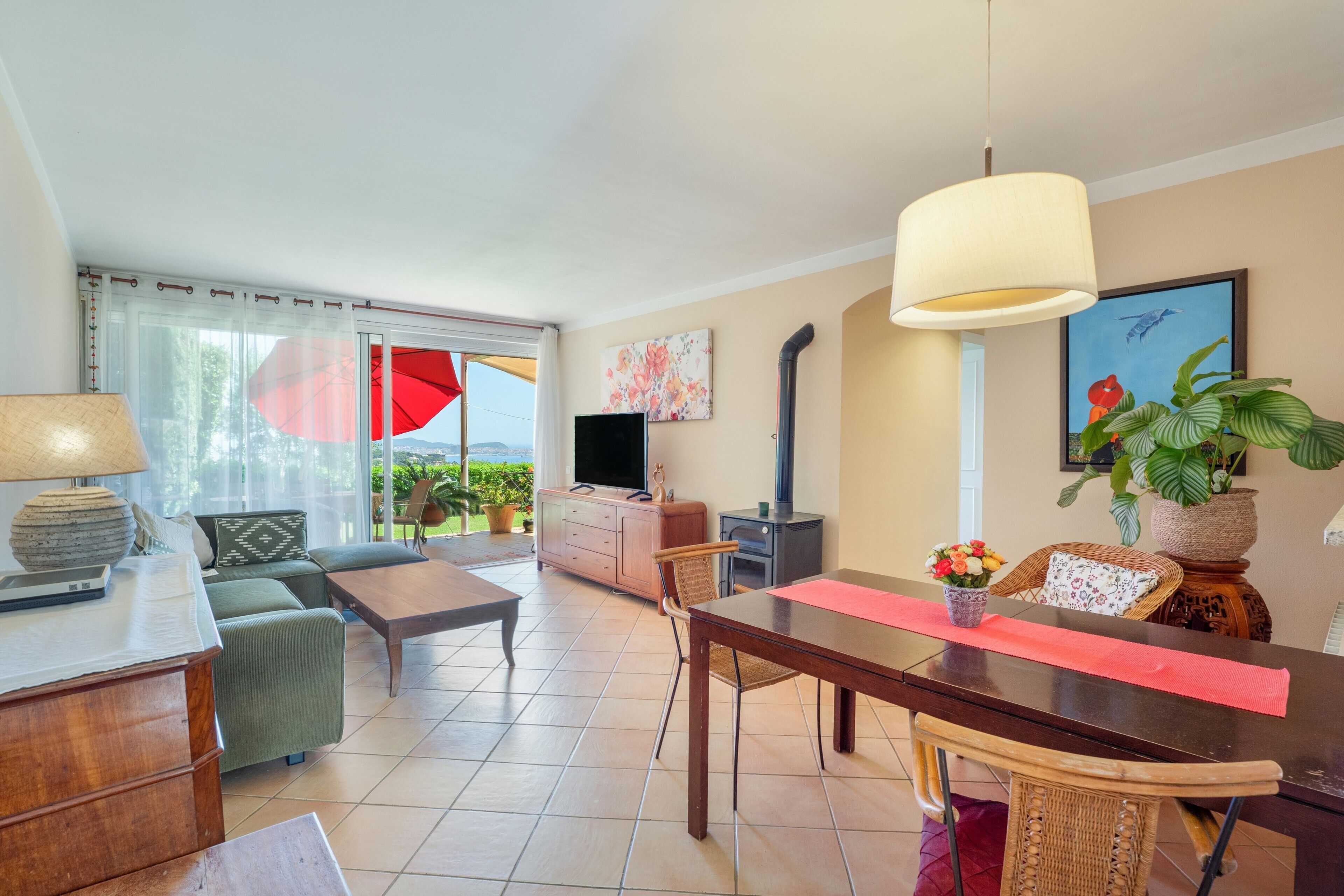 Ein Wohnzimmer mit einer Couch, einem Couchtisch, einem Fernseher und einem Esstisch mit Stühlen.