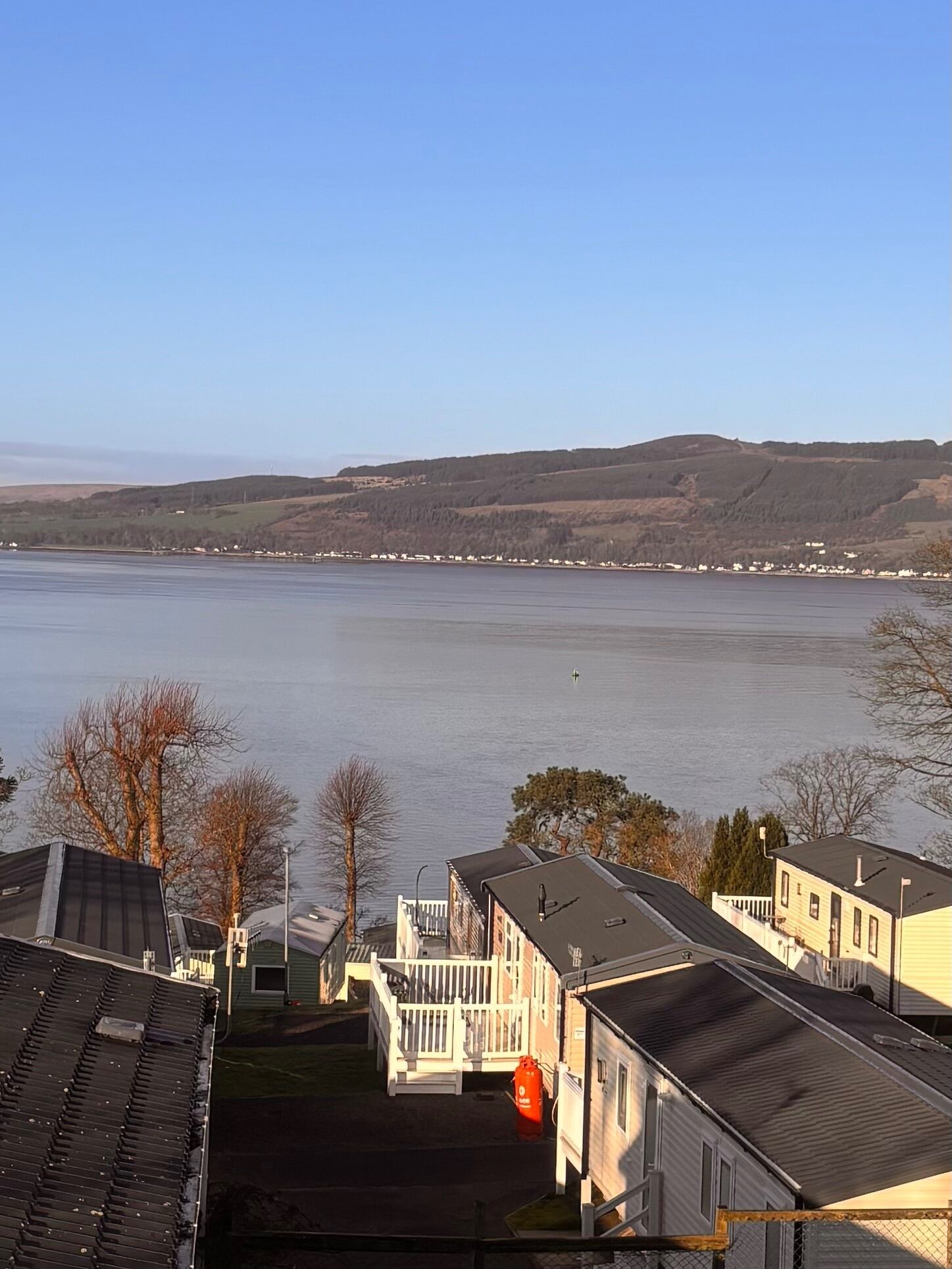 Une vue sur le lac, avec des maisons et un quai.