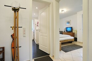 Ein Hotelzimmer mit Bett, Fernseher, Schreibtisch und Stuhl.