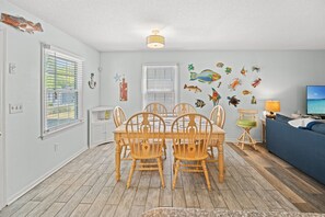 Un coin repas avec une table et des chaises en bois, un téléviseur et un canapé.