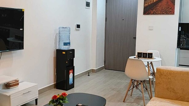 Een moderne woonkamer met een bank, salontafel, televisie en een schilderij aan de muur.