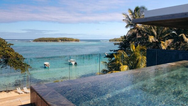 Ein klarer Blick auf einen Pool mit Meerblick und einer kleinen Insel.