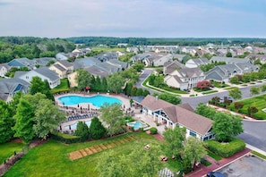 A residential area with houses, a swimming pool, and well-maintained lawns.