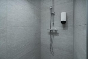 Standaard studio | Badkamer | Een douche, een haardroger, handdoeken, zeep