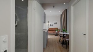 Un interior moderno con ducha, cocina, comedor y sofá.