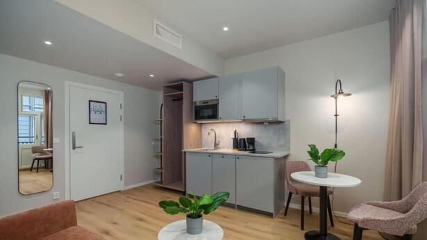 Un apartamento moderno con kitchenette, zona de comedor y sala de estar.