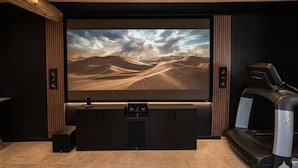 A home theater with a large flat-screen TV, a sound system, and a treadmill. - Mas en Provence (Eyguières)