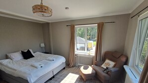 Ein Schlafzimmer mit Bett, Stuhl, Fenster und Heizkörper.