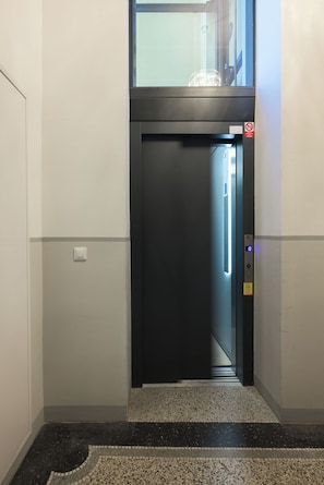 Ein Aufzug mit digitaler Anzeige, Bedienfeld und Warnschild.