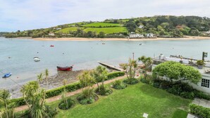 A coastal view with boats, a beach, and a grassy area with trees. - 24 The Salcombe (Salcombe)
