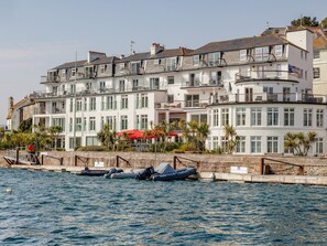 A multi-story building with balconies, a waterfront view, and a red umbrella. - 24 The Salcombe (Salcombe)