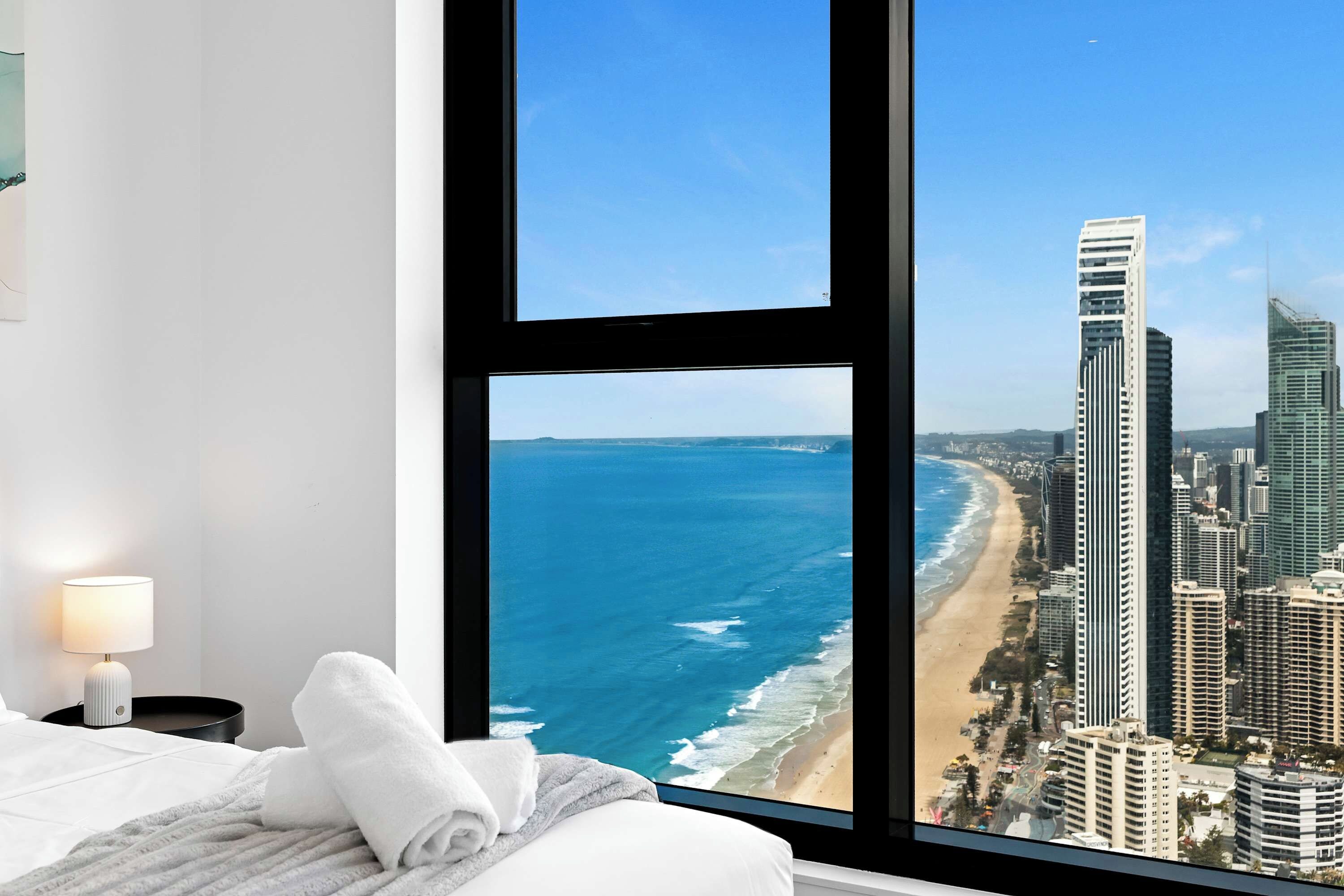 Relax in bed while enjoying front-row vistas of the deep blue ocean and surrounding high-rise skyline