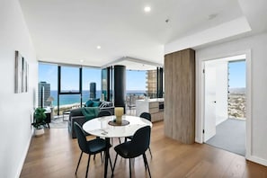 Ein zeitgemäßer Wohnraum mit Essbereich, einer Küche und einem Balkon mit Blick auf die Stadt.