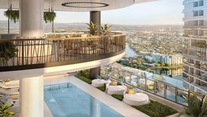 A modern rooftop lounge with a pool, seating areas, and a view of the cityscape. - Lvl 36 Ocean Views | 2BR skyhome | sky pool (Broadbeach)
