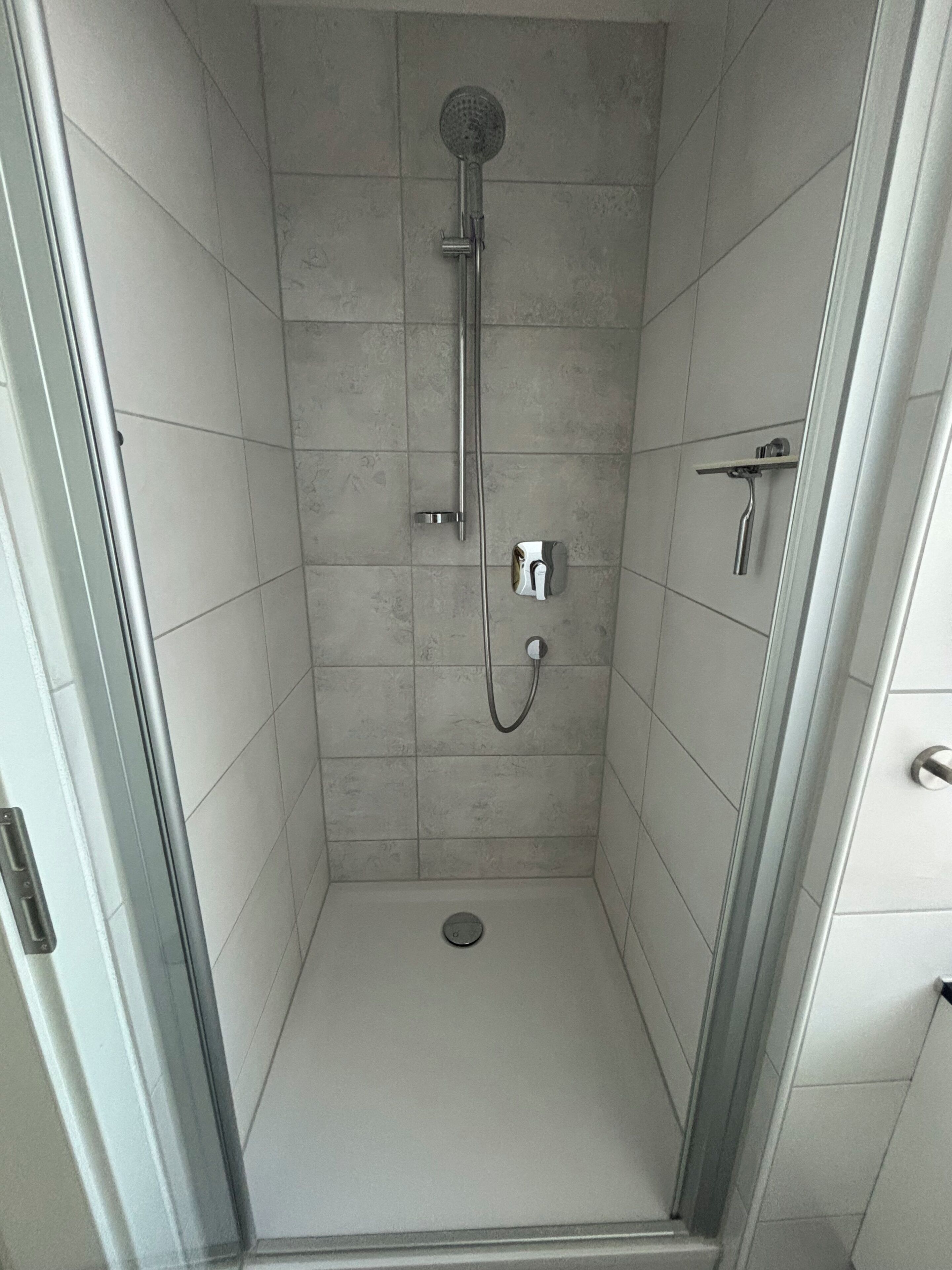Een douche, een haardroger, handdoeken, toiletpapier