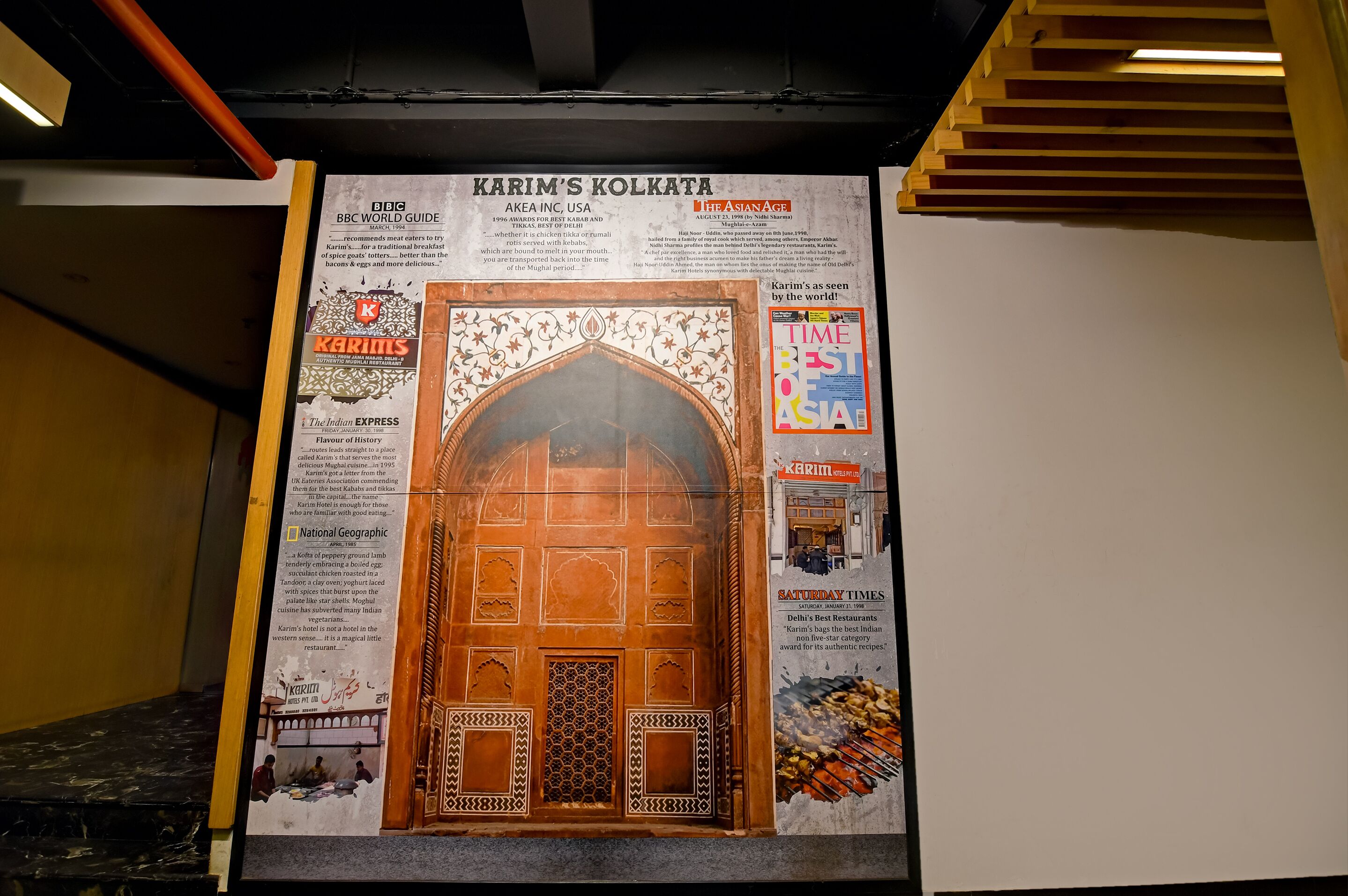 A poster of Karim's Kolkata with a traditional Indian archway and a Times of India magazine.