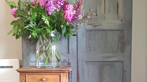 A wooden cabinet with a vase of flowers.