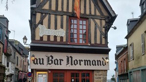 A traditional half-timbered building with a sign reading 'Au Bar Normand.'