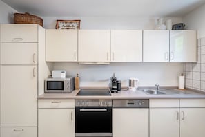 A modern kitchen with white cabinets, a built-in oven, a microwave, and a coffee maker. - Bächle Lodge with 3 Bedrooms and Mountain Views in the Heart of Hornberg (Hornberg)
