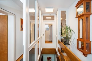 A hallway with a wooden bench, a potted plant, and a wall-mounted clock. - Bächle Lodge with 3 Bedrooms and Mountain Views in the Heart of Hornberg (Hornberg)