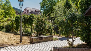A paved pathway, a lamppost, and a building with a sloped roof in a garden setting. - Bächle Lodge with 3 Bedrooms and Mountain Views in the Heart of Hornberg (Hornberg)