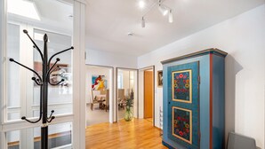 A hallway with a coat rack, a blue cabinet with floral designs, and a dining area in the background. - Bächle Lodge with 3 Bedrooms and Mountain Views in the Heart of Hornberg (Hornberg)