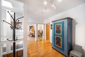 A hallway with a coat rack, a blue cabinet with floral designs, and a dining area in the background. - Bächle Lodge with 3 Bedrooms and Mountain Views in the Heart of Hornberg (Hornberg)