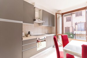 A modern kitchen with grey cabinets, a white countertop, and a red chair. - Modern apartment 1, 5M Montepulciano with parking (Toscana)