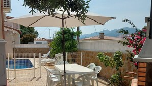 A patio with a table and chairs, a swimming pool, and a view of mountains. - Central house with private pool - 4 guests (Mont-roig del Camp)