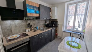 Uma cozinha moderna com forno embutido, máquina de café e área de jantar com mesa e cadeiras.
