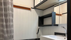 Une salle de bain avec une baignoire, un lavabo, un miroir et une douche.