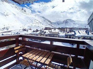 A snowy mountain town with buildings and a wooden deck. - Charming duplex, mountain view, pets welcome - 8 guests (Tignes)