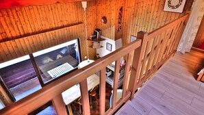 A wooden interior with a wooden staircase, a window overlooking a street, and a small desk with a computer. - Studio with mezzanine near village center - 4 guests (Le Grand-Bornand)