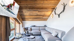 Ein modernes Wohnzimmer mit einem Ecksofa, einem runden Couchtisch und einem Kamin.