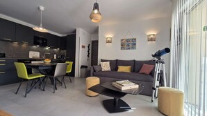 Un salon moderne avec un canapé, une table basse et un télescope.