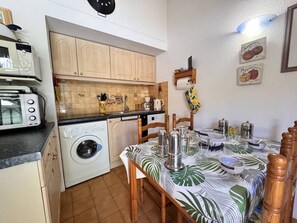 A compact kitchen with a washing machine, a microwave, and a toaster. - Calm villa club, lake view - 4 guests (Six-Fours-les-Plages)