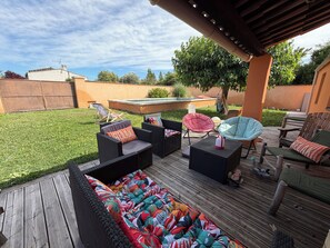 A deck with outdoor furniture, a pool, and a grassy yard. - Comfortable air-conditioned house in the heart of Provence (L'Isle-sur-la-Sorgue)