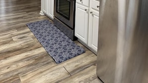 A modern kitchen with stainless steel appliances, white cabinetry, and a patterned rug. - Charming Cottage with Pool. Close to shops, restaurants and farms (West Cape May)